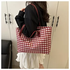 Side view of red and white houndstooth tote bag on model for casual commuting style