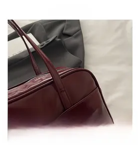 Detail shot of the dark red leather pillow bag with top zipper and fine stitching
