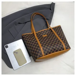 Detailed view of the checkered tote bag with yellow leather trim and interior capacity