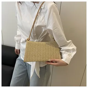 Detail of beige woven straw shoulder bag featuring intricate texture and knot strap design