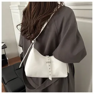 Detailed view of white minimalist leather hobo bag with silver rivet strap decorations
