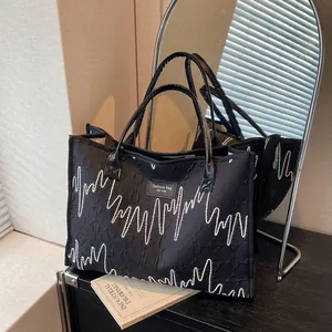 Black quilted tote bag with colorful embroidery and fashion tag for stylish women