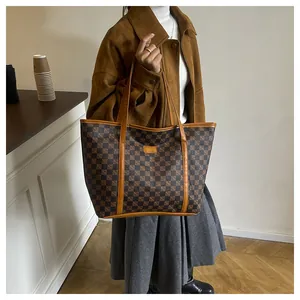 Detailed close-up of brown checkerboard tote bag with elegant leather straps and gold logo