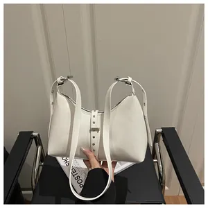 Detail view of the white leather hobo bag with silver buckles and a crescent silhouette