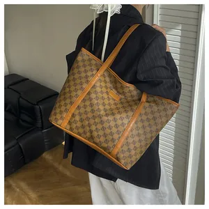 Close-up of brown leather stitching and classic monogram pattern on a large tote bag
