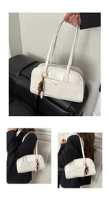 Detail of cream PU leather shoulder bag featuring decorative beads and front pocket