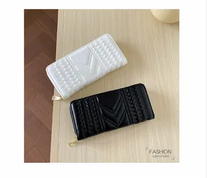 Detail view of long PU leather wallets with V-shaped quilting and golden metal zippers
