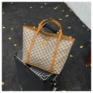 Detail of vintage geometric tote bag with leather trim placed on a suitcase for travel