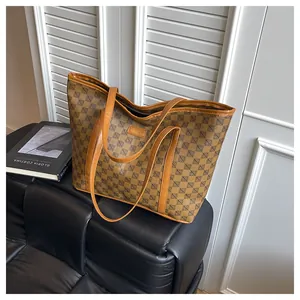 Detail of printed tote bag with leather handles on a sofa in a modern urban setting