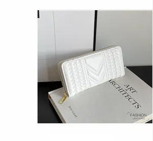 Detailed view of white long wallet with V-shaped quilting and gold metal zipper