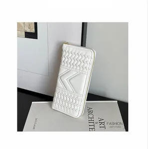Detail of white quilted women's long wallet featuring M-shaped stitching and gold zipper