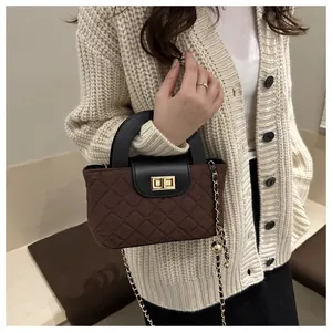 Close-up of quilted pattern brown and black crossbody bag with gold chain strap