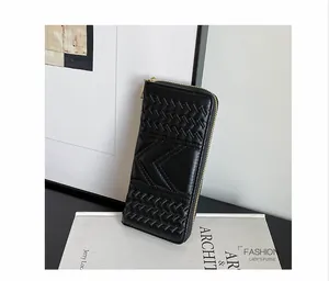 Detail of elegant black long wallet for women with V-stitch and woven texture details