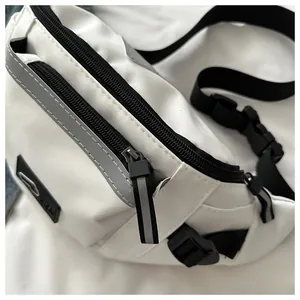 Detail of white nylon chest bag featuring black adjustable straps and safety reflective strip