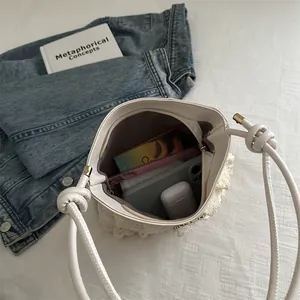 Chic white lace crochet bucket bag featuring leather handles and spacious interior