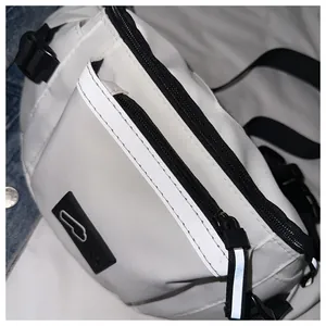 Detail of white nylon crossbody bag featuring reflective strips and dual zippers