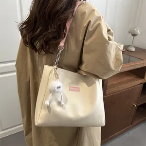 Grand sac fourre-tout beige en cuir PU avec lanières roses et un charm monstre peluche