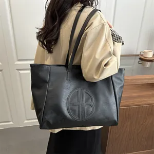 Stylish black leather tote bag with embossed circular logo for women office commute style