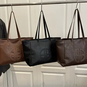 Three oversized PU leather tote bags in brown, black and coffee with logo embossing