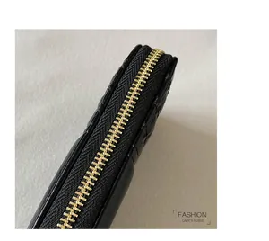 Detail of premium gold metal zipper on a black quilted leather fashion lady's purse