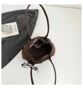 Interior detail of large brown suede tote bag showing purple lining and zipper pocket