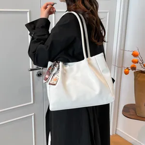 Large white faux leather tote bag with a decorative brown silk scarf and long handles