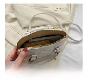 Internal view of beige quilted shell bag showing space for phone and wallet