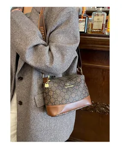 Detail of vintage brown printed crossbody bag with gold kangaroo logo and wide strap
