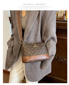 Detail of vintage patterned crossbody bucket bag with wide woven strap and metal logo