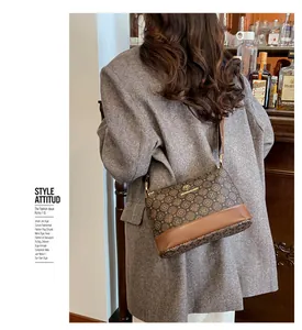 Detail shot of vintage pattern crossbody bag with golden kangaroo logo on a gray suit