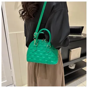 Green shell crossbody bag with quilted texture shown with casual fashion outfit