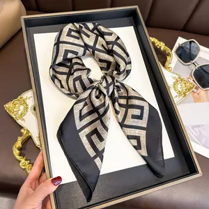 Vintage black and gold silk-like square scarf with geometric maze pattern displayed on tray