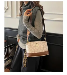 Detail of vintage crossbody bag with geometric patterns and branded webbing shoulder strap