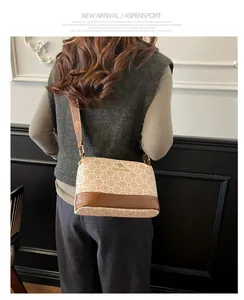 Detail of vintage patterned crossbody bag with kangaroo logo and wide strap shown on model