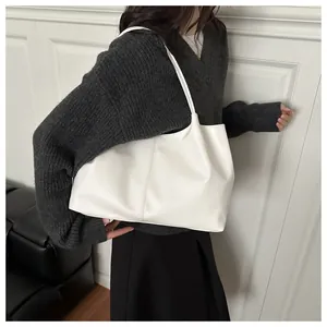Detailweergave van een witte minimalistische grote shopper gedragen door een model