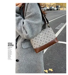 Retro patterned crossbody bucket bag featuring a gold kangaroo logo and brown base