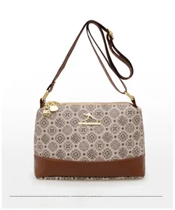 Close-up of vintage print crossbody bag with gold kangaroo emblem and brown leather base