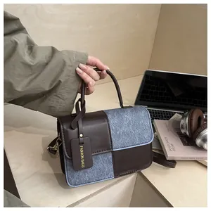 Close-up of retro color-block handbag with textured wool and leather splicing details