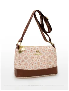 Detail view of floral print crossbody bag with golden kangaroo logo and fabric strap