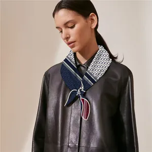 Detail of velvet square scarf with blue and white geometric patterns on a leather jacket