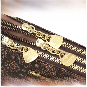 Detail of vintage printed bucket bag featuring triple gold zippers and kangaroo metal logos