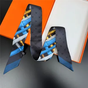 Detailed macro view of high-quality silk twilly scarf with heart patterns and orange box