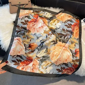 Detail of vintage floral silk scarf with vibrant orange peony patterns and black borders