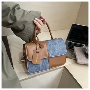 Detail of stylish patchwork handbag with brown leather, grey felt, and fashion tag