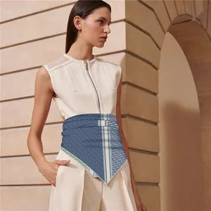 Detail of silk square scarf tied at waist with navy monogram and pastel border
