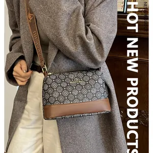 Vintage printed crossbody bucket bag with brown leather base and adjustable wide strap
