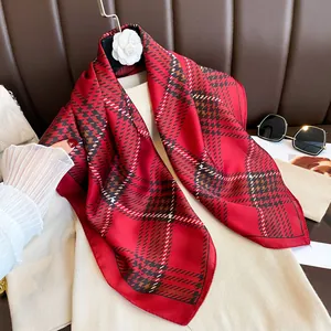 Close-up of a red plaid silk scarf with satin finish on a camellia hanger