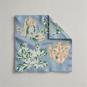 Detailed view of luxury silk scarf with blue tulip print and hand-rolled edges