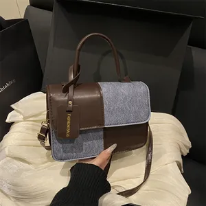 Fashionable patchwork crossbody handbag in brown leather and grey textured fabric