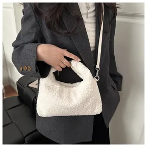 Gros plan du sac seau blanc en laine avec boucle en métal sur un mannequin élégant